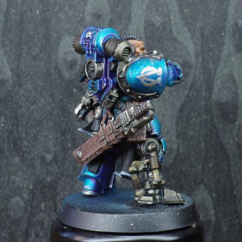 Right side view, showing the alpha legion icon on the shoulder pad made up of the Alpha and inverded omega Greek letters. It also shows their prosthetic right leg
