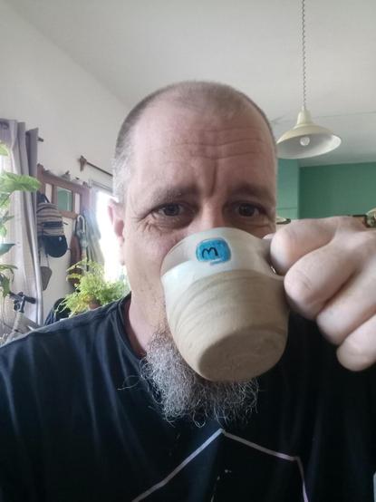 yo tomando cafe en una taza mastodon de Ceramica del Pez