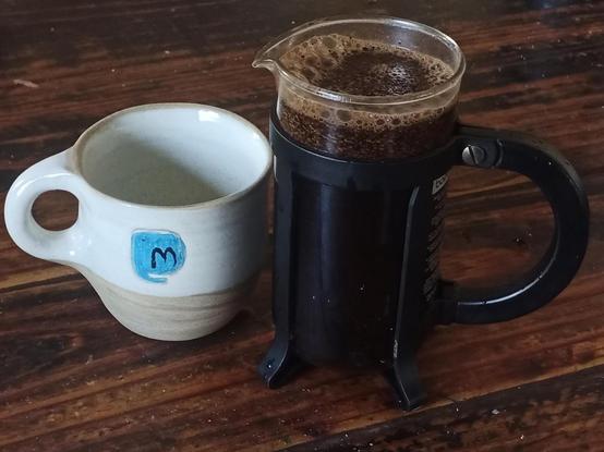 taza de mastodon y cafetera de prensa con cafe