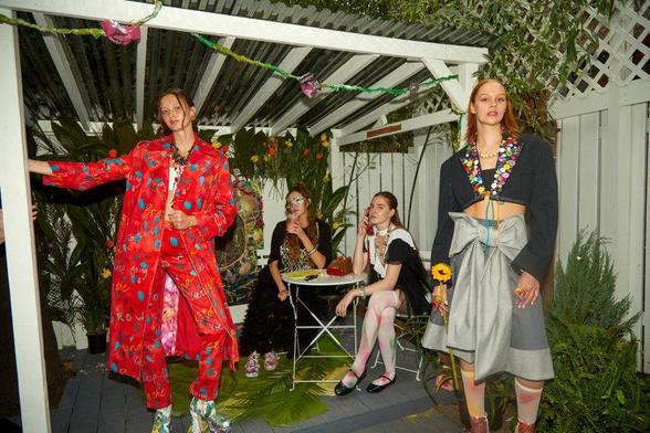 Models in upcycled designs, two standing, two seated.