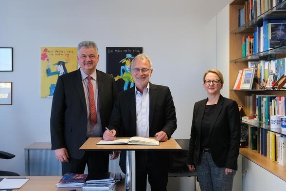 Von links nach rechts: Prof. Sebastian M. Schmidt, Wissenschaftlicher Direktor des HZDR, Dr. Martin Keller, Direktor des National Renewable Energy Laboratory (NREL) in den USA, und Dr. Diana Stiller, Kaufmännische Direktorin des HZDR während des Eintrags ins Gästebuch des Helmholtz-Zentrums Dresden-Rossendorf.