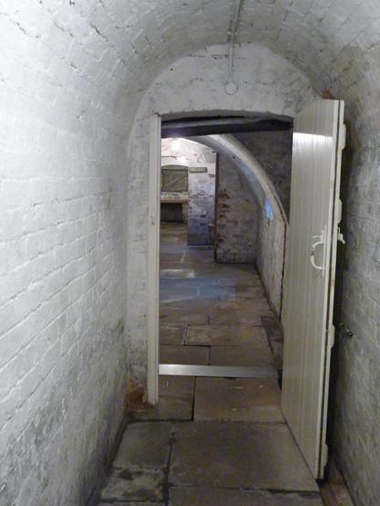 Whitewashed brickwork, sone flagged floor: a corridor in the basement of a Victorian-built workhouse.