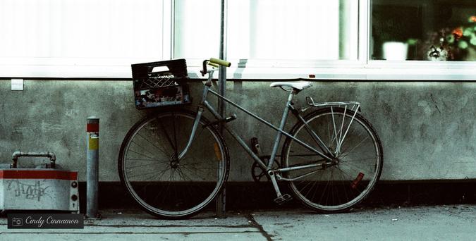 Vélo avec un panier en caisse de lait en milieu urbain. Photographie par Cindy Cinnamon