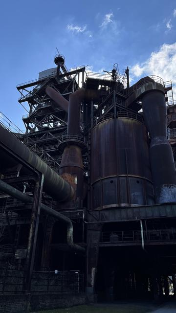 Monströs ragen die Stahlbauten in den blauen Himmel

The steel buildings rise monstrously into the blue sky