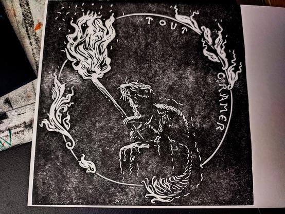 Closer view of the linocut print with the pyromaniac squirrel. It sits in a circle with flame looking like art nouveau intertwining