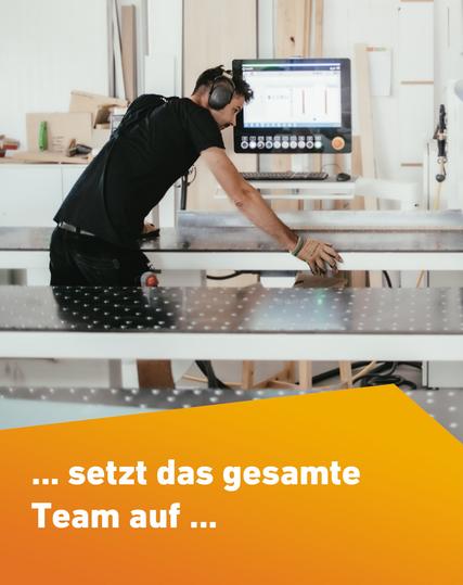 Ein Tischler bei der Arbeit an einer liegenden Plattensäge.