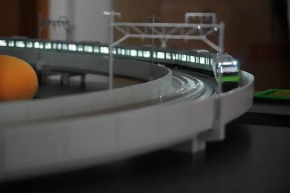 A close up shot of the front of a train coming through the bend of the model train set-up.