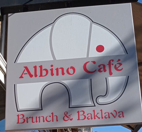 das Logo und Ladenschild des "Albino Café" in Detmold sieht aus wie ein Elefant, der sich nicht entscheiden kann, ob er sich als Croissant tarnen möchte, oder doch lieber so aussehen will wie der süße Cousin von Kagube