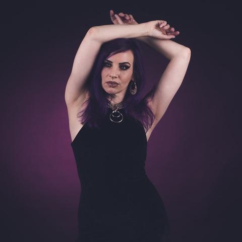 Dunkelhaariges Model vor violett angeblitzten Hintergrund.