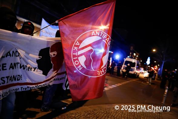 Der Demonstrationszug bewegte sich durch den Stadtteil Moabit, begleitet von der Polizei. Auf diesem Bild ist eine Fahne der Antifaschistischen Aktion und ein weißes Banner zu sehen.