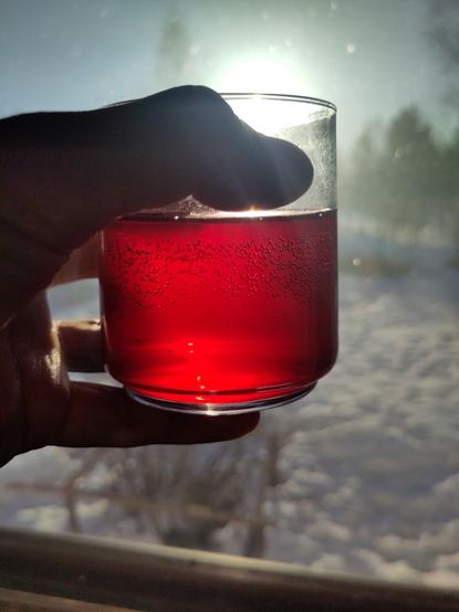 Kädessä lasi, lasissa kauniin punaista nestettä, simaa.