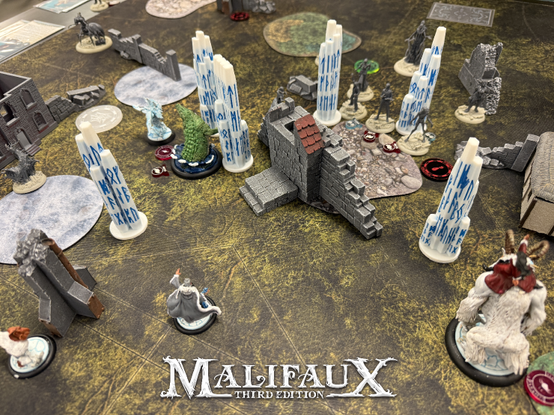 A tabletop skirmish game in progress, showing skillfully painted good guy minis against unpainted bad guy minis, with terrain placed randomly around and good guy runed ice pillars helping stem the infection from the bad guy, unpainted, face-eating zombies.

I'm not taking sides here. Any neutral observer would be able to instantly tell who the good guys and the bad guys were, here, and probably would insist that the good guys be given extra points just for being so cool and well-painted, maybe 10? extra points? In fact, it's pretty clear I probably won 12-4. Take that, Austin. I'm changing the game result spreadsheet in light of this new information.