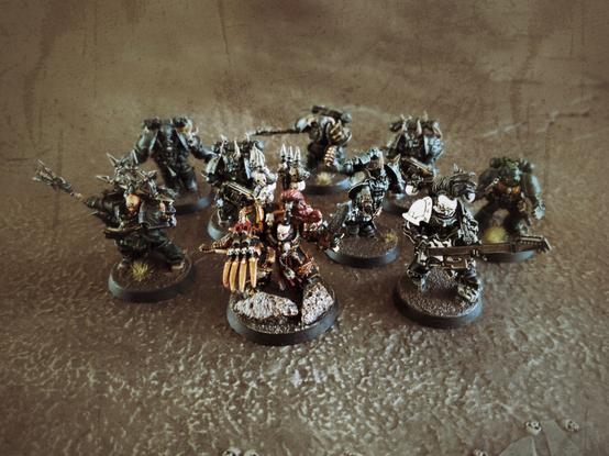 A group of older chaos space marine characters including abaddon, a noise marine, a chaplain and the chosen from the dark vengeance box.
