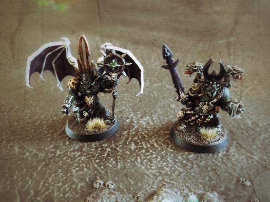 Two old metal chaos space marine sorcerer sculpts. One of them was kitbashed to have wings.