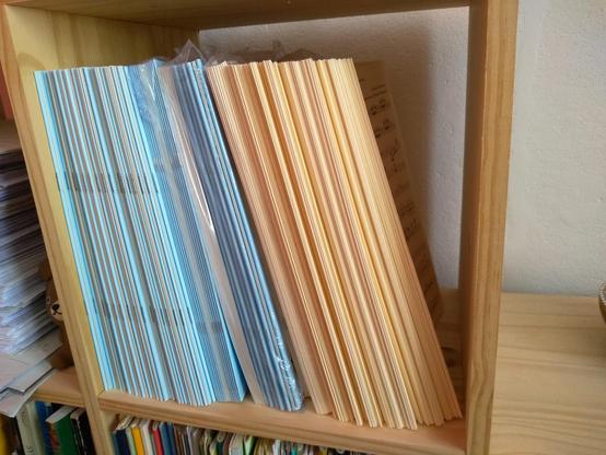 Un stock de partitions auto-éditées dans un meuble de rangement en bois, dans mon bureau