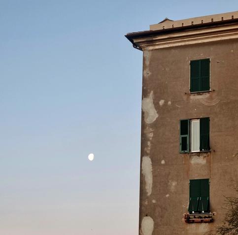porzione di palazzo con cielo sereno e luna sullo sfondo