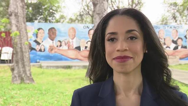 Former Houston City Council member, Amanda Edwards. In the background, the mural of the history of Houston's Fifth Ward "On whose shoulders do you stand?"