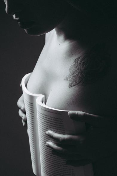 Chica con libro en el pecho en blanco y negro.