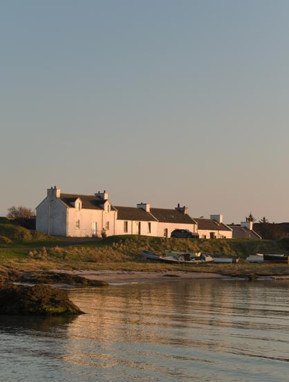 white houses with slate roofs by the sea at sunset