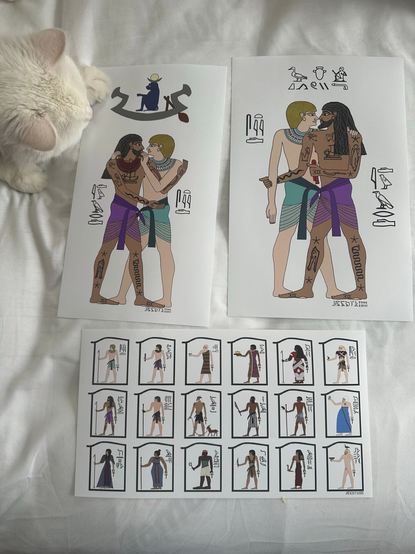 Photo showing 3 colour drawings in the style of ancient Egyptian art, laid out on a bedsheet and guarded by a white cat, whose head can be seen in the top left corner of the photo. 1: Ed & Stede standing close together, looking into each other's eyes, their arms & legs entwined as Stede places a red collar necklace around Ed's neck. Stede himself is wearing a similar necklace but in teal. They are both wearing identical wrap skirts - Stede's is teal and Ed's is purple. Ed's tattoos have been replaced with hieroglyphs. Next to Edward and Stede, their names are spelled phonetically in hieroglyphs. Above the pair is a blue baboon sitting in a stylised boat, the full moon balanced on its head. 2: Stede & Ed standing close with their noses touching, one of Stede's hands on Ed's shoulder and one of Ed's hands on Stede's forearm. Ed is holding a folded piece of red silk in his other hand. Hieroglyphs next to them spell their names, and another set of hieroglyphs above them translates to 'two intimate friends', according to Briana's description on AO3, plus a penis hieroglyph just for fun. 3: a print showing 18 small drawings of individual characters from OFMD, including Ed, Stede and their respective crews, as well as Jackie, Zheng & Auntie. They are each depicted with one or several items relevant to their character, and their name written in phonetic hieroglyphs next to them.