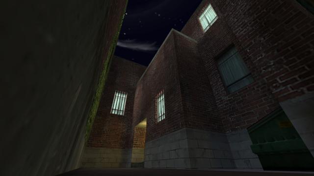 In this picture you can see what is behind the tunnel. A brick building. You can see a total of four windows, three of which have lights and two windows have metal grilles. You can also see an entrance. A little to the right is a dumpster. This is on the map cs_backalley in the game Counter-Strike 1.6.