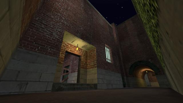 In this picture you can see the entrance. Above this, a yellow-lit lamp hangs from the ceiling. In addition, you can see into a hallway, where you can see a nailed door. This is on the map cs_backalley in the game Counter-Strike 1.6.