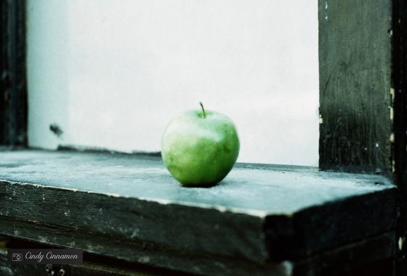 Pomme abandonnée sur le bord d’un édifice en ville par quelqu’un qui ne la voulait pas… Photographie par Cindy Cinnamon