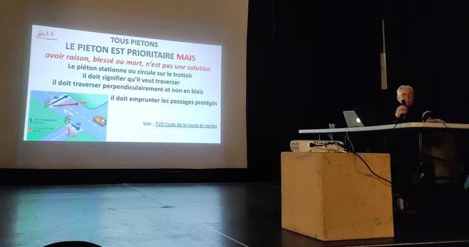 un vieux homme blanc assis à côté d'un vidéoprojecteur. le projecteur montre le premier diapo de la présentation dans le lien, entitré "Le Piéton est prioritaire MAIS... avoir raison, plessé ou mort, n'est pas une solution"