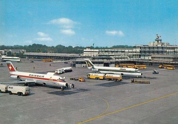 Several Planes are parked at remote stands waiting for passengers in the case of the Alitalia planes, and cargo in the case of the SwissAir planes.