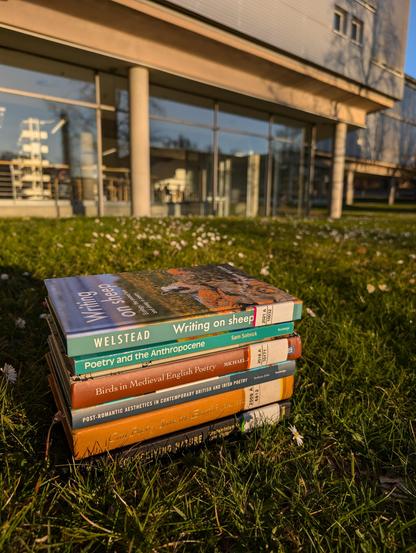 A stack of 6 books on nature poetry on the meadow in front of SUB Göttingen