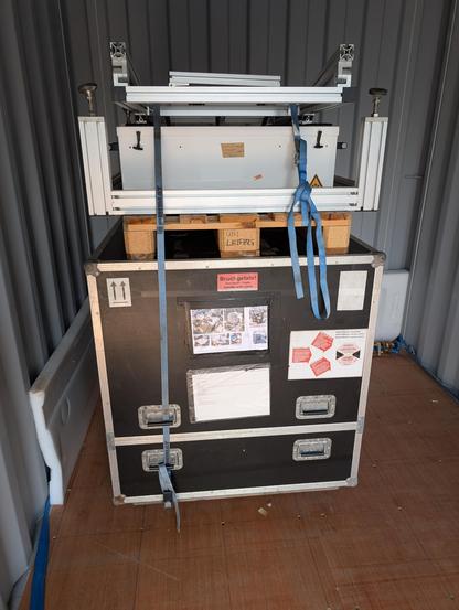 A packed cloud radar in a black box with mounting tables on top within a sea container.