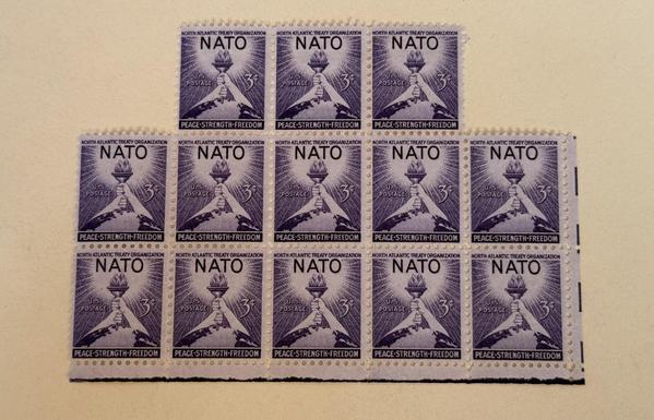A number of beautiful purple stamps, which read NATO and have hands holding a torch