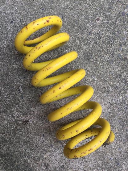 large yellow painted metal spring
