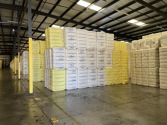 Rows and rows of cotton bales in a cotton warehouse.