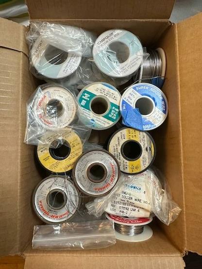 A box of a large amount of various solder spools.