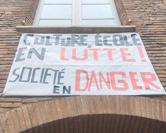 Affiche "culture, école en lutte ! Société en danger !" Au-dessus de l'entrée de la Cave Poésie à Toulouse.