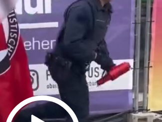 A policemen running away, after he easily removed something that looks like a megaphon from the grip of an antifascist protestor.