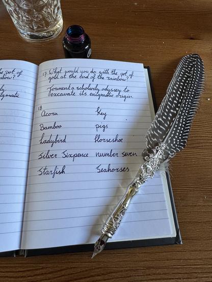 Notebook, quill and cursive handwriting on wooden table. 

The text:

17, What would you do with the pot of gold at the end of the rainbow?
Foment a scholarly odyssey to excavate its enigmatic origin.

18,

Acorn, Bamboo, Ladybird, Silver sixpence, starfish, key pigs, horseshoe, number seven, seahorses.