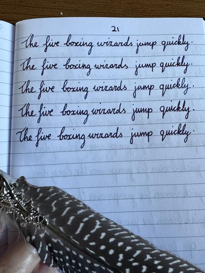 Notebook, cursive text. 21. The five boxing wizards jump quickly.The five boxing wizards jump quickly.The five boxing wizards jump quickly.The five boxing wizards jump quickly.The five boxing wizards jump quickly.