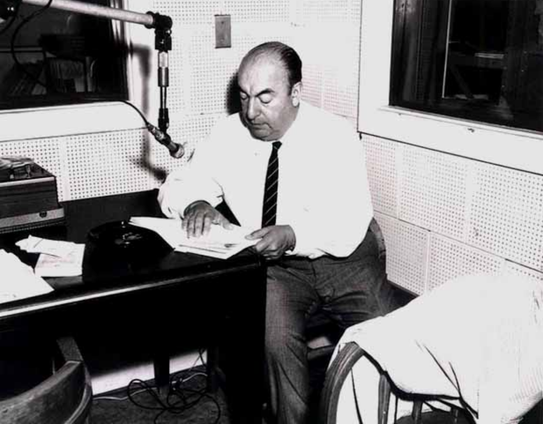 Schwarz-weiß Fotografie: Pablo Neruda in einem Tonstudio, aus einem Manuskript lesend.