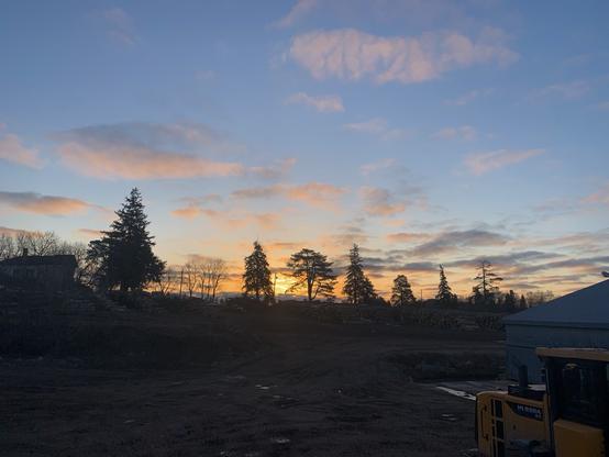 The morning sunrise. The sky is a calm blue with a few clouds. The golden light is creeping up slowly