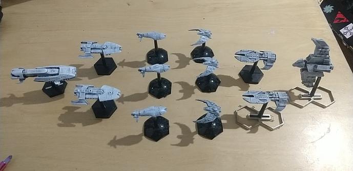 Twelve little metal and plastic spaceships on a table.