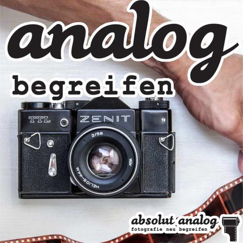 Ein Bild einer Zenit Analogkamera, Schriftzug “analog begreifen”