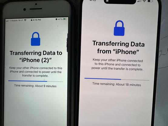Two iPhones, side by side, each displaying a screen indicating that data is being transferred between them. One has “about 9 minutes remaining” indicated on the progress bar, the other reports “about 18 minutes”.
