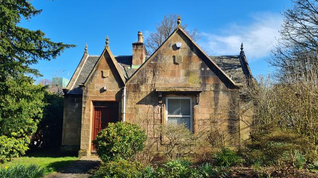 A small, stone lodge built at the entrance to a large Georgian-era country estate.