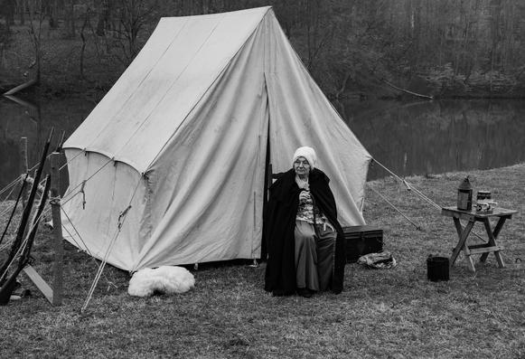 An old woman sitting in front of her tent at the camp site of the Battle Of Guilford Courthouse reenactment.  Photo taken on March 15, 2025, 244 years to the day since this important battle of the American Revolutionary War was fought.
