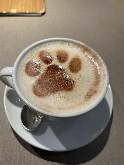 a cup of coffe with a paw print on top