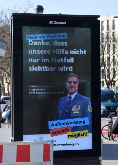 Ein Werbebildschirm an einer Straße mit der Botschaft "Danke, dass unsere Hilfe nicht nur im Notfall sichtbar wird".
