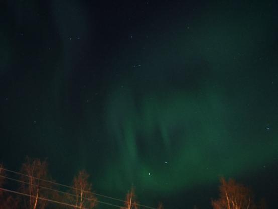 Nighly long exposure photograph of aurora borealis on sky.
