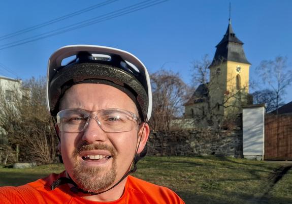Cyklista, v pozadí kostel svatých apoštolů Jana a Pavla v Kutné Hoře - Malíně